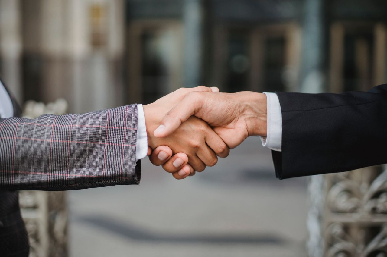 services-02 A close-up of two businesspeople shaking hands, symbolizing cooperation and partnership.