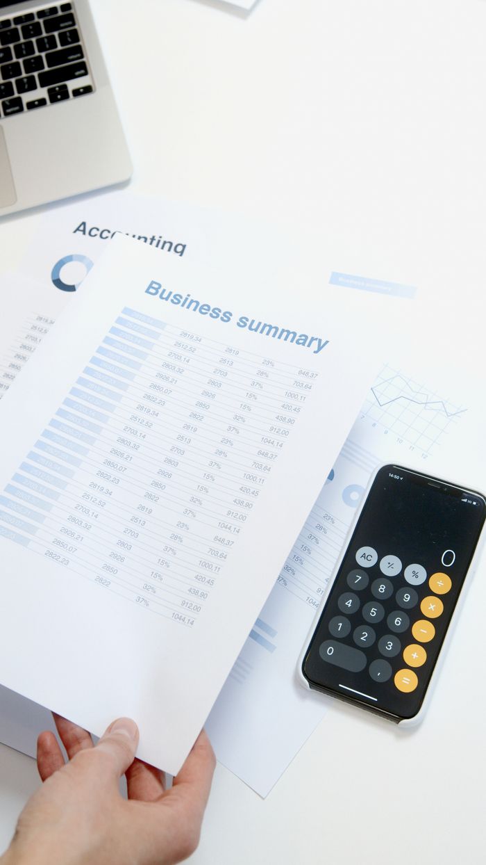 about-us-02 Business summary sheet with a calculator on a desk for financial analysis.